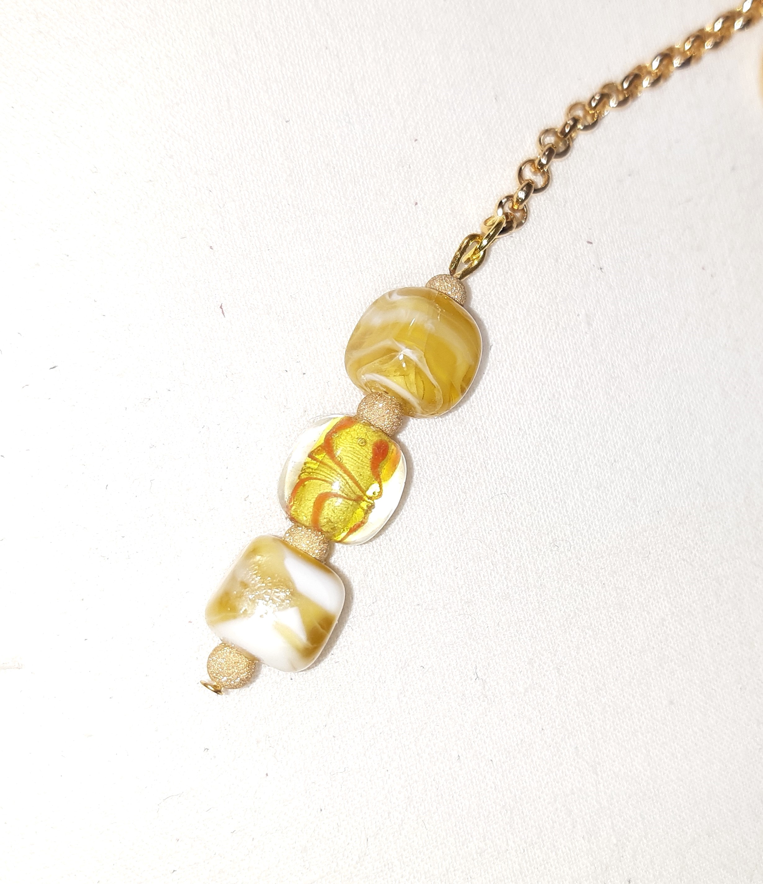 Bijou de sac, pompon cuir coloris jaune avec billes en verre filé et cloisonné.