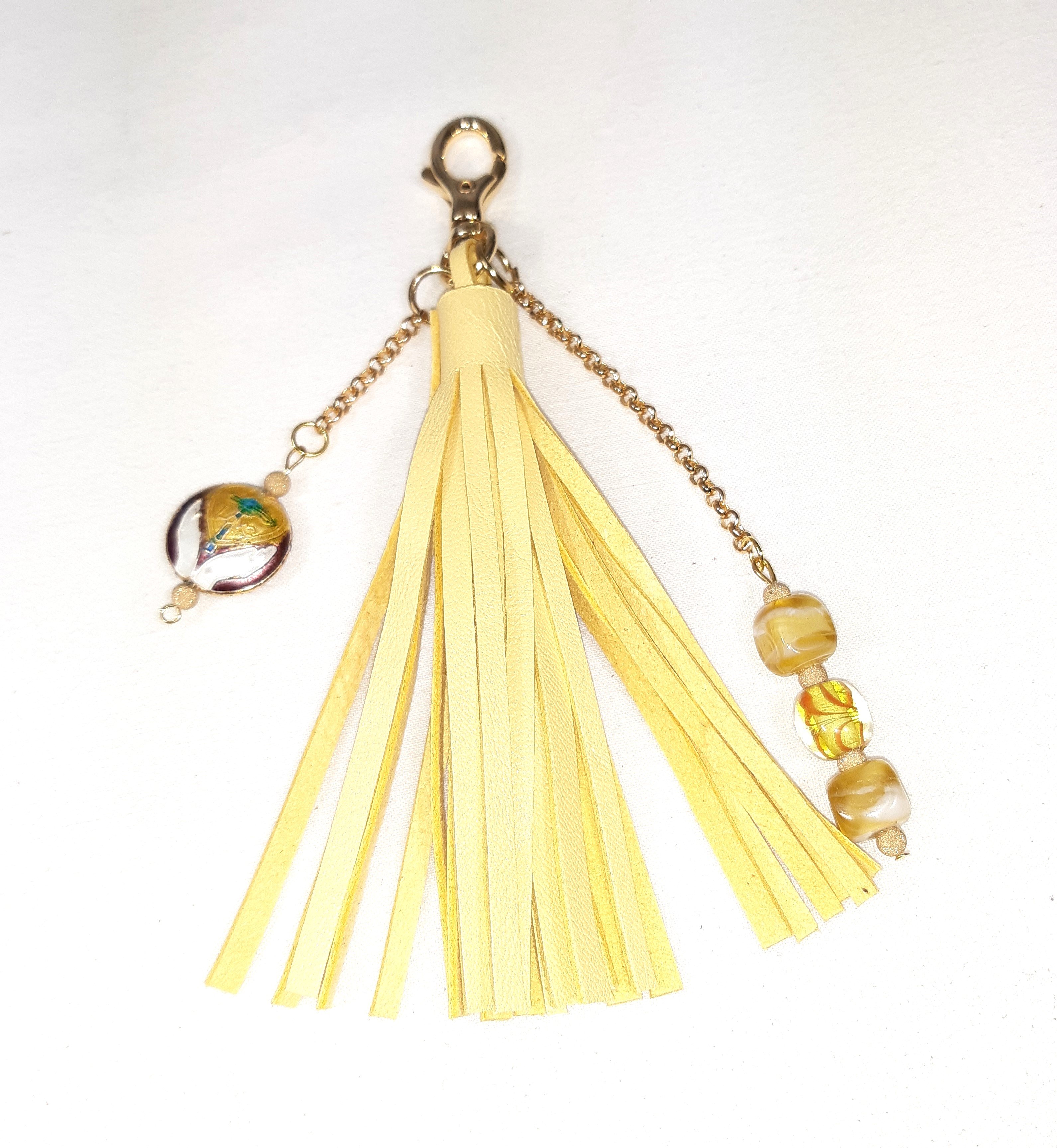 Bijou de sac, pompon cuir coloris jaune avec billes en verre filé et cloisonné.